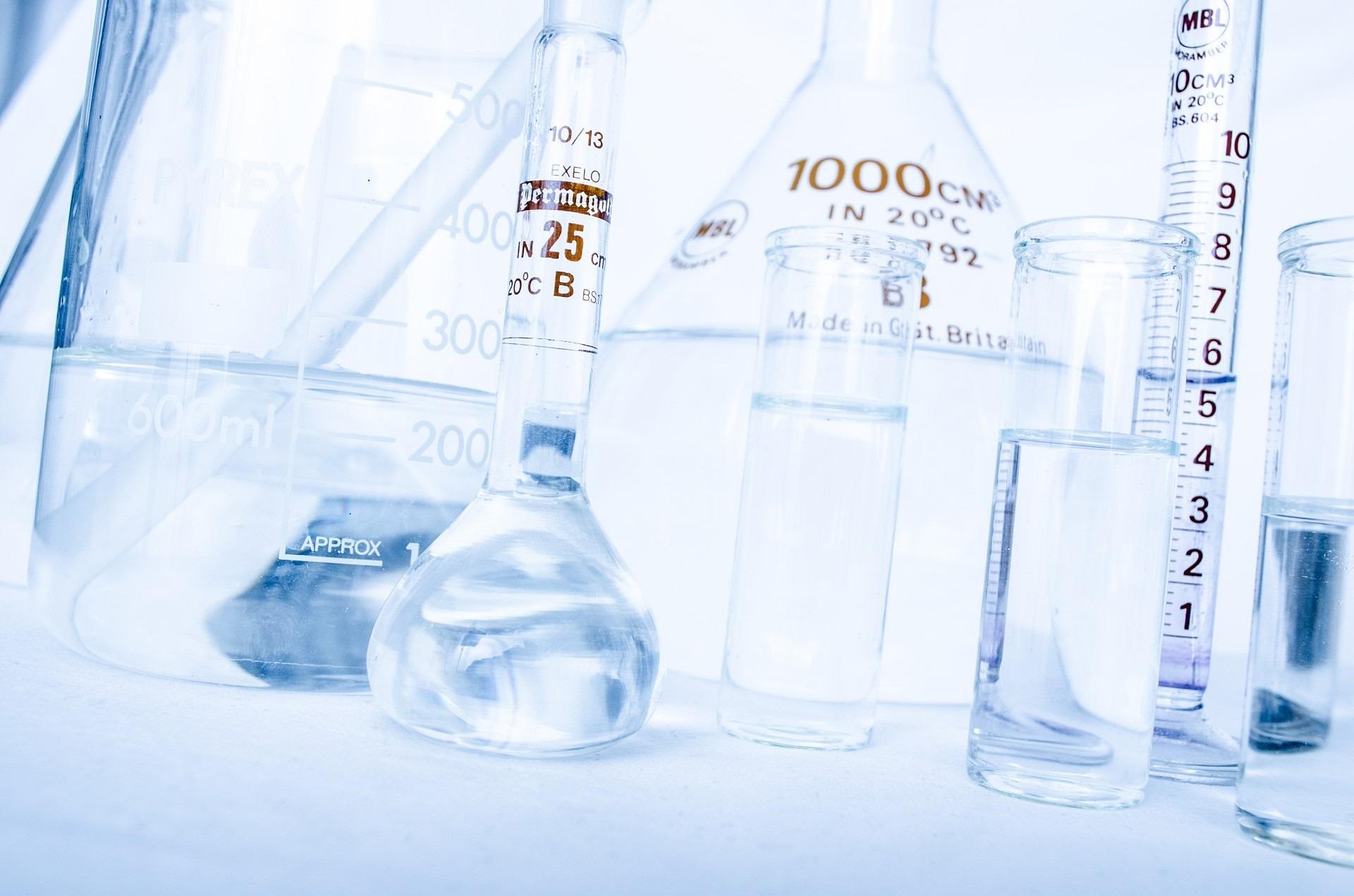 Bright laboratory glassware including beakers, test tubes, and graduated cylinders.
